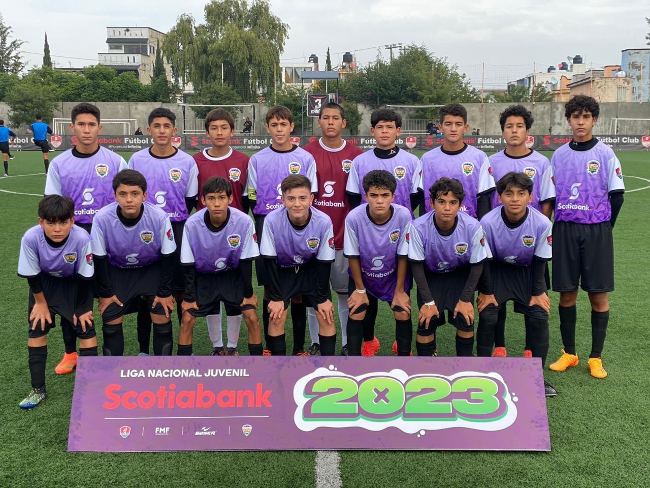 Niños posando para una foto en una cancha de futbol