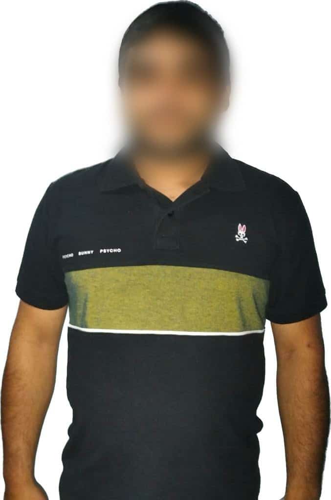 Una persona con el rostro tapado y una playera color negra con una franja dorada