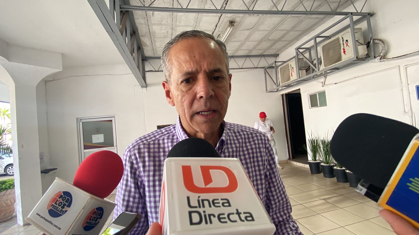 Una persona y micrófonos de medios de comunicación