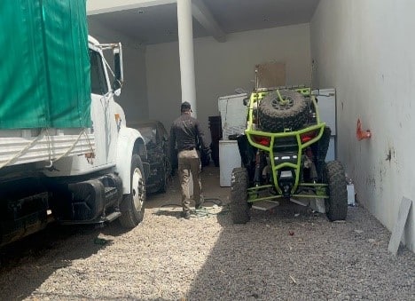 La parte de un camión, un carrito tipo razer y una persona de espaldas caminando entre las 2 unidades