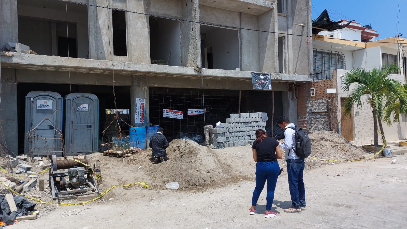 Edificio de departamentos, escombros y personas