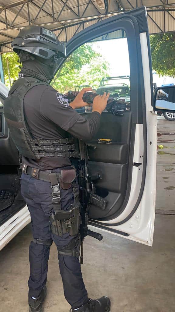 Agente de la Policía retira el polarizado de una patrulla.