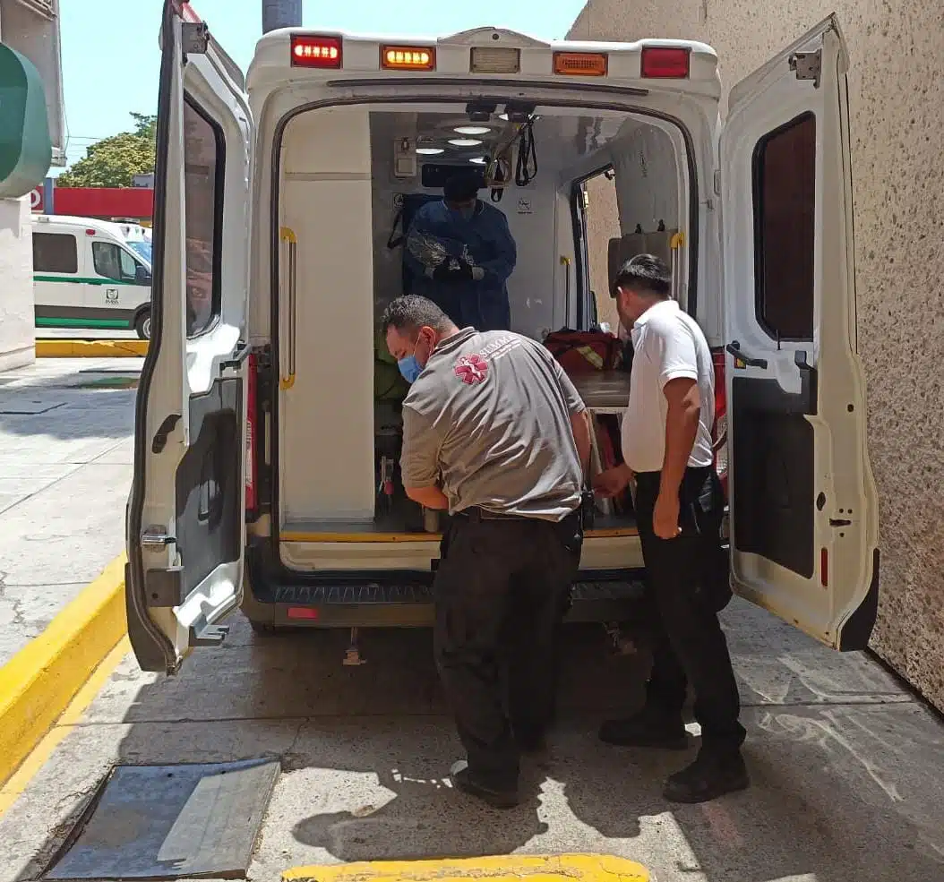 Paramédicos bajando a paciente de una ambulancia