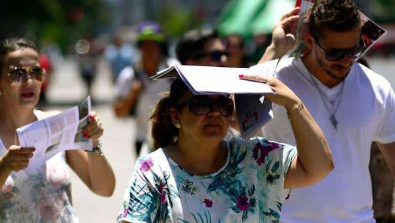 Señora tapándose el sol por calor en Culiacán