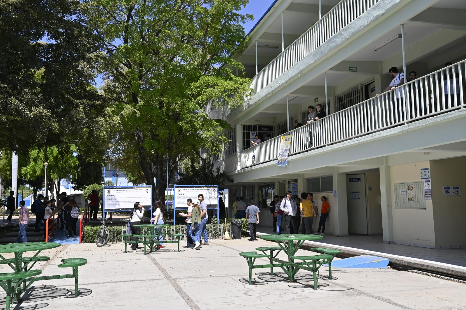 Bancas, personas y un edificio de 3 pisos