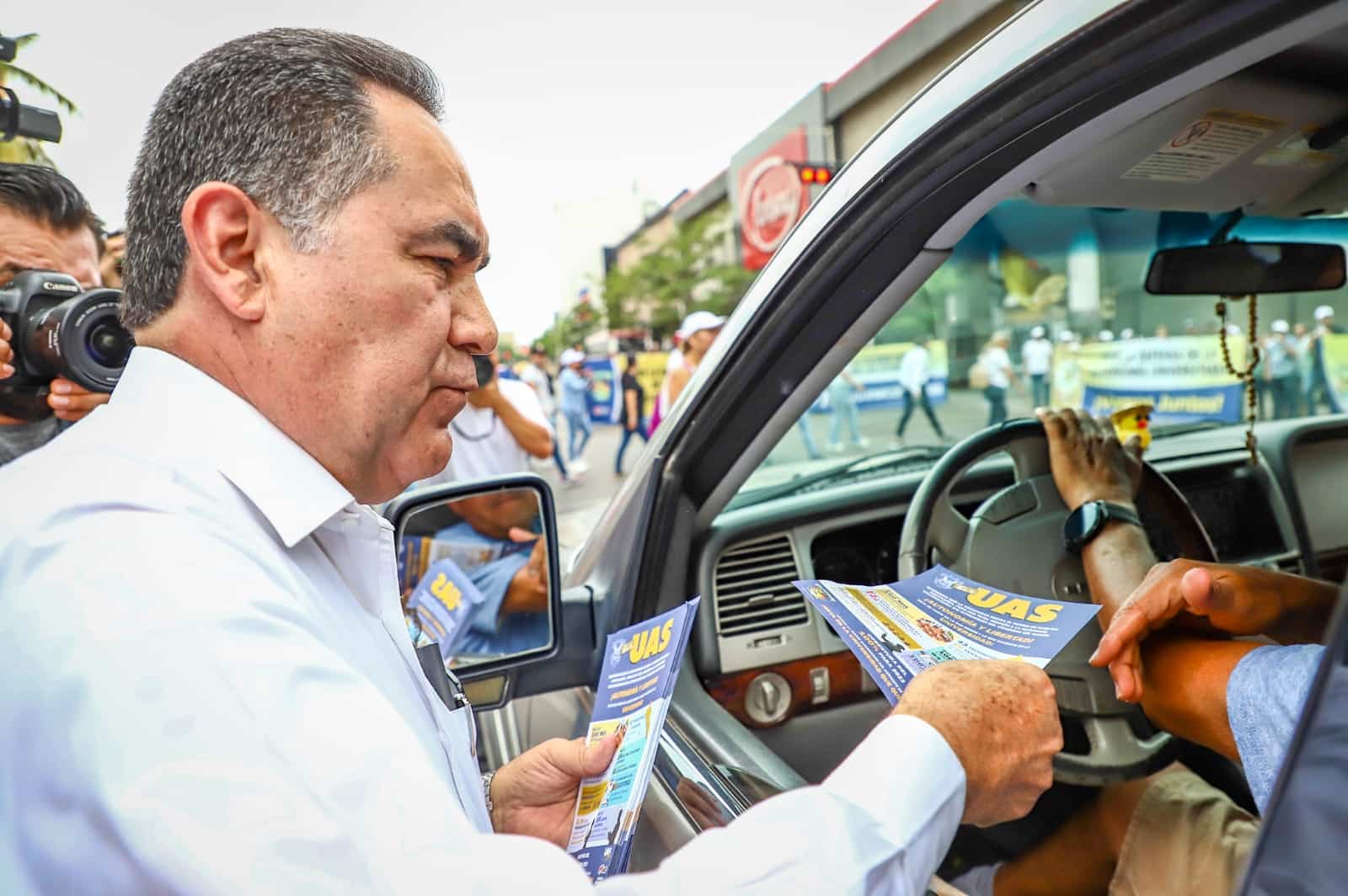 El rector Jesús Madueña Molina repartiendo volantes en manifestación ante inicio de proceso legal en su contra