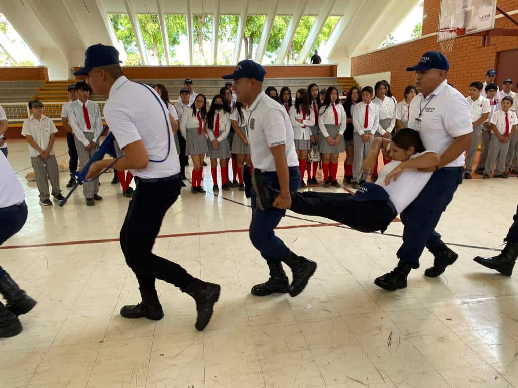 Personas mirando como otras van cargando a otra y otra con un arma en las manos