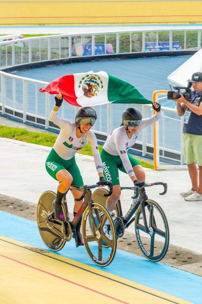 Las ciclistas sinaloenses Yarely Salazar y Antonieta Gaxiola, portando la bandera de México tras conquistar el oro en la prueba de Madison en San Salvador
