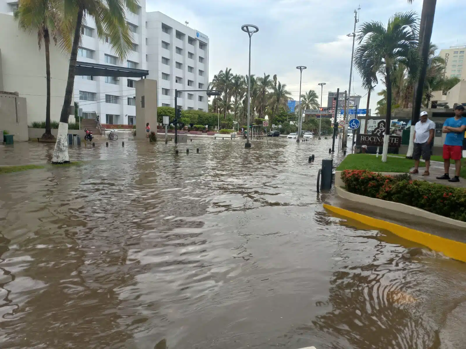 Avenida inundada, personas mirando y al fondo hoteles