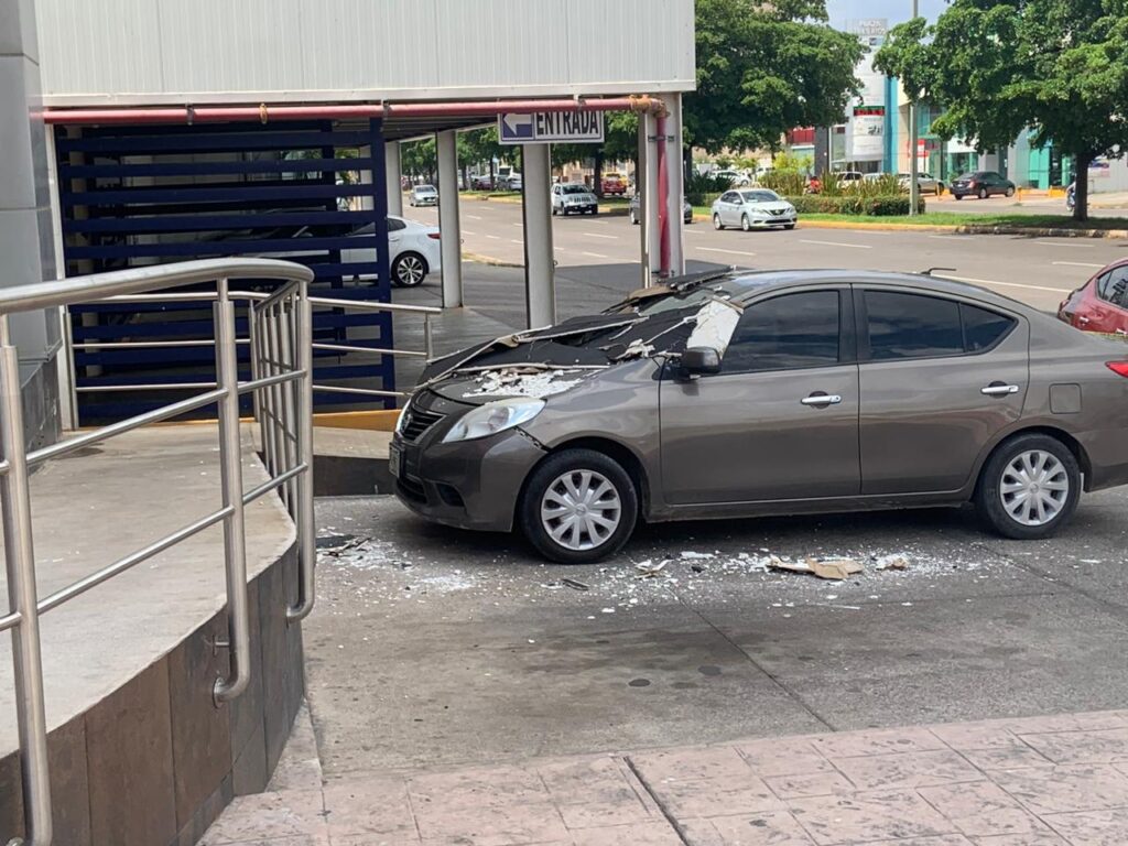 Se derrumba estructura desde las alturas de plaza del Tres Ríos y cae a vehículo Nissan Versa color gris, en Culiacán. 