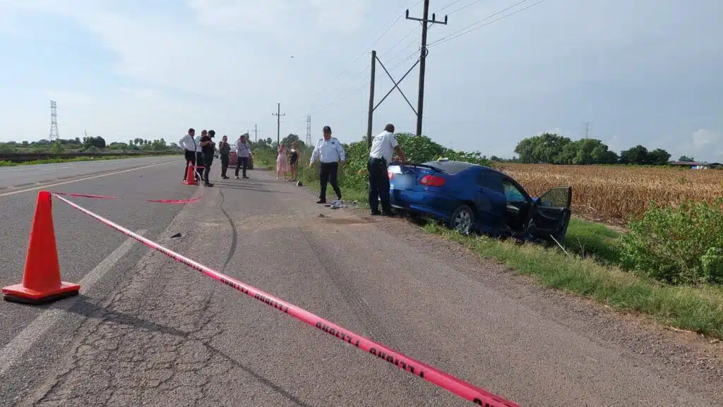 Zona acordonada donde se encuentra un vehículo accidentado fuera de la carretera. Agentes policiacos y civiles se encuentran en el lugar