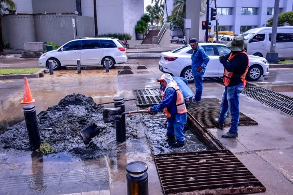 Trabajadores limpiando calles inundadas en Mazatlán