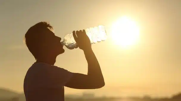 Hombre bebiendo agua por el Calor