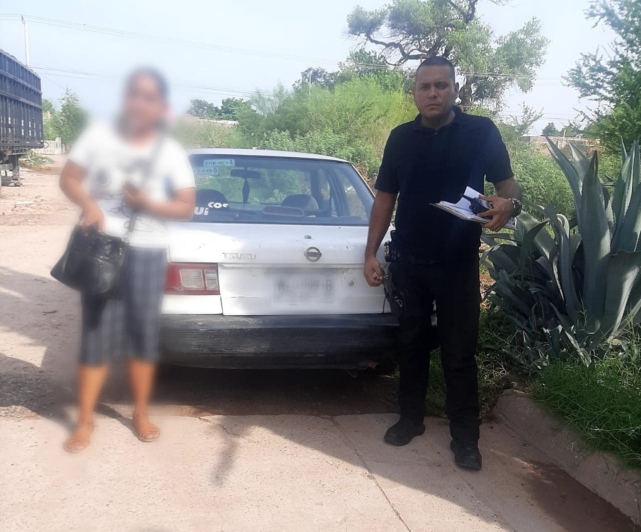 Agente policiaco entregando vehículo con reporte de robo a su dueño