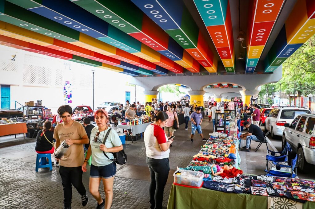 Personas disfrutando del bazar bajo el puente de Lego