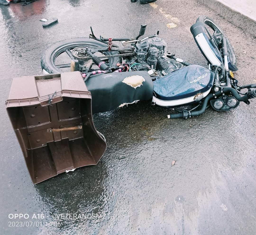Motocicleta de reparto tirada sobre el pavimento húmedo