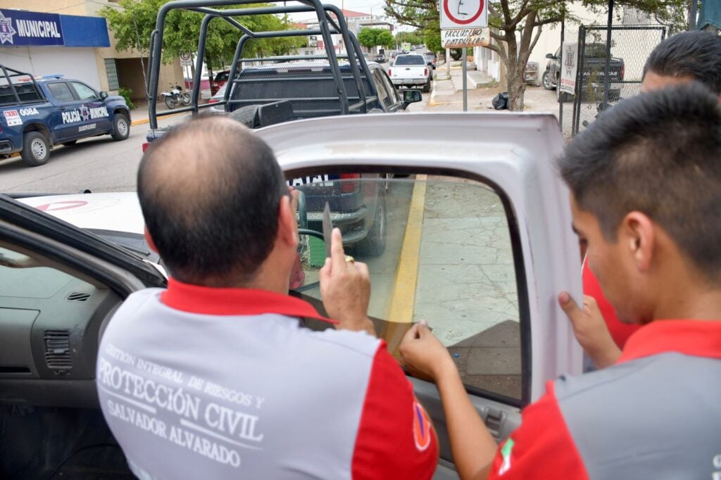 Personal de Protección Civil retirando también el polarizado de su unidad