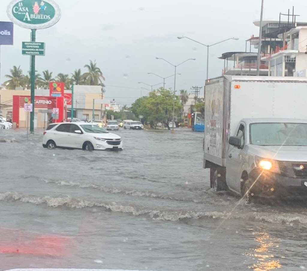 Dos vehículos pasando por una zona inundada