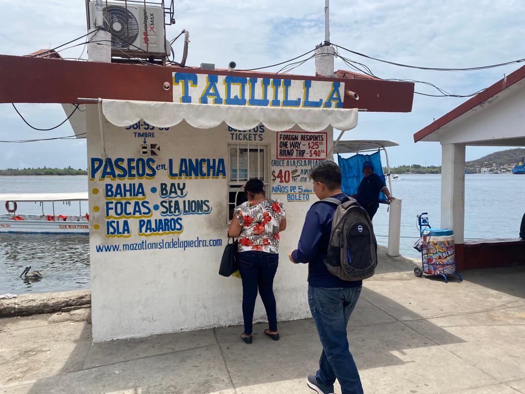 Personas comprando en la taquilla de lanchas