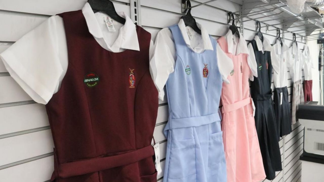 Uniformes escolares de nivel secundaria exhibidos en una pared