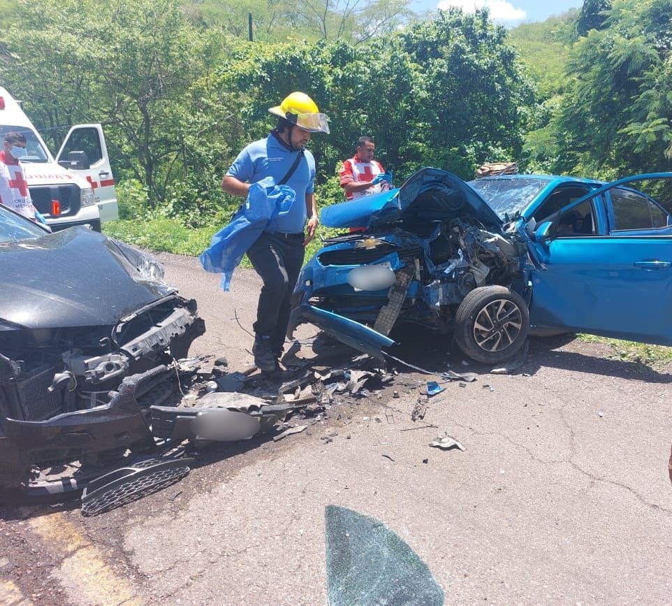 Dos vehículos destrozados de la parte delantera. Personal de Cruz Roja y Protección Civil se encuentra en el lugar