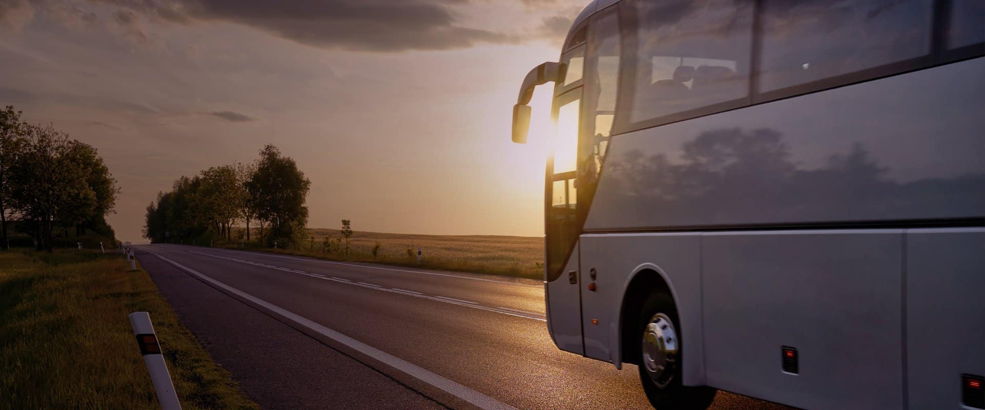 Autobús por la carretera en el atardecer