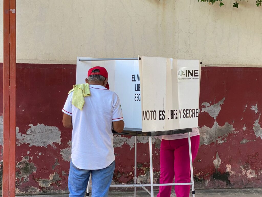 Persona votando en urna