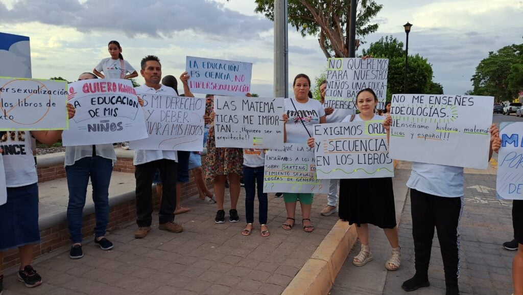 Padres de familia con cartulinas en manifestación en contra de contenidos sexual de los libros de texto