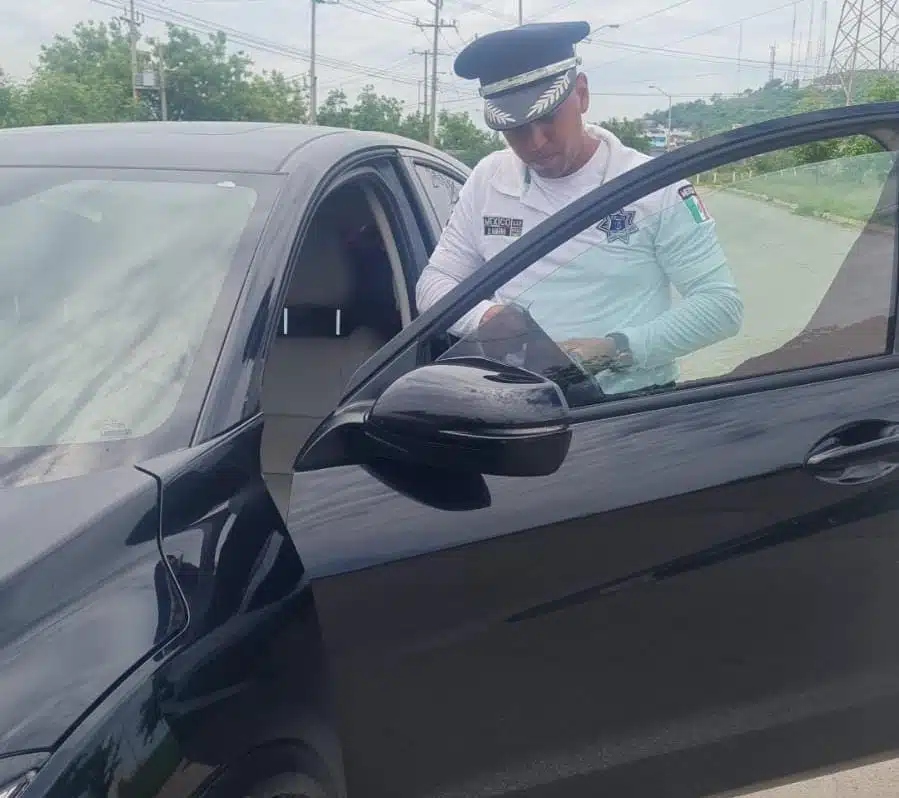 Oficial de tránsito realizando retiro de polarizado a un vehículo