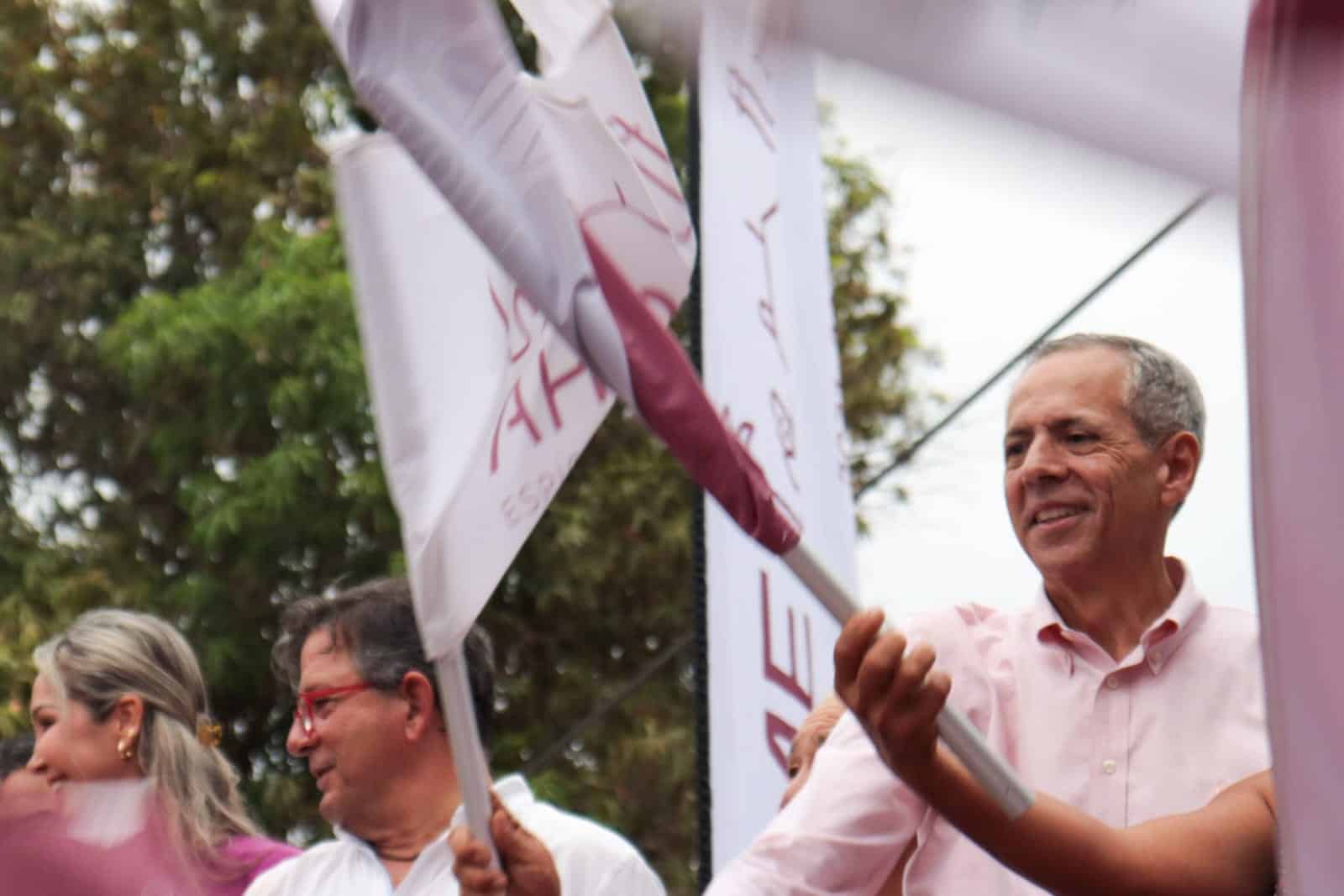 Alcalde de Ahome sosteniendo la bandera de inauguración de la pavimentación en el Ejido Macapule