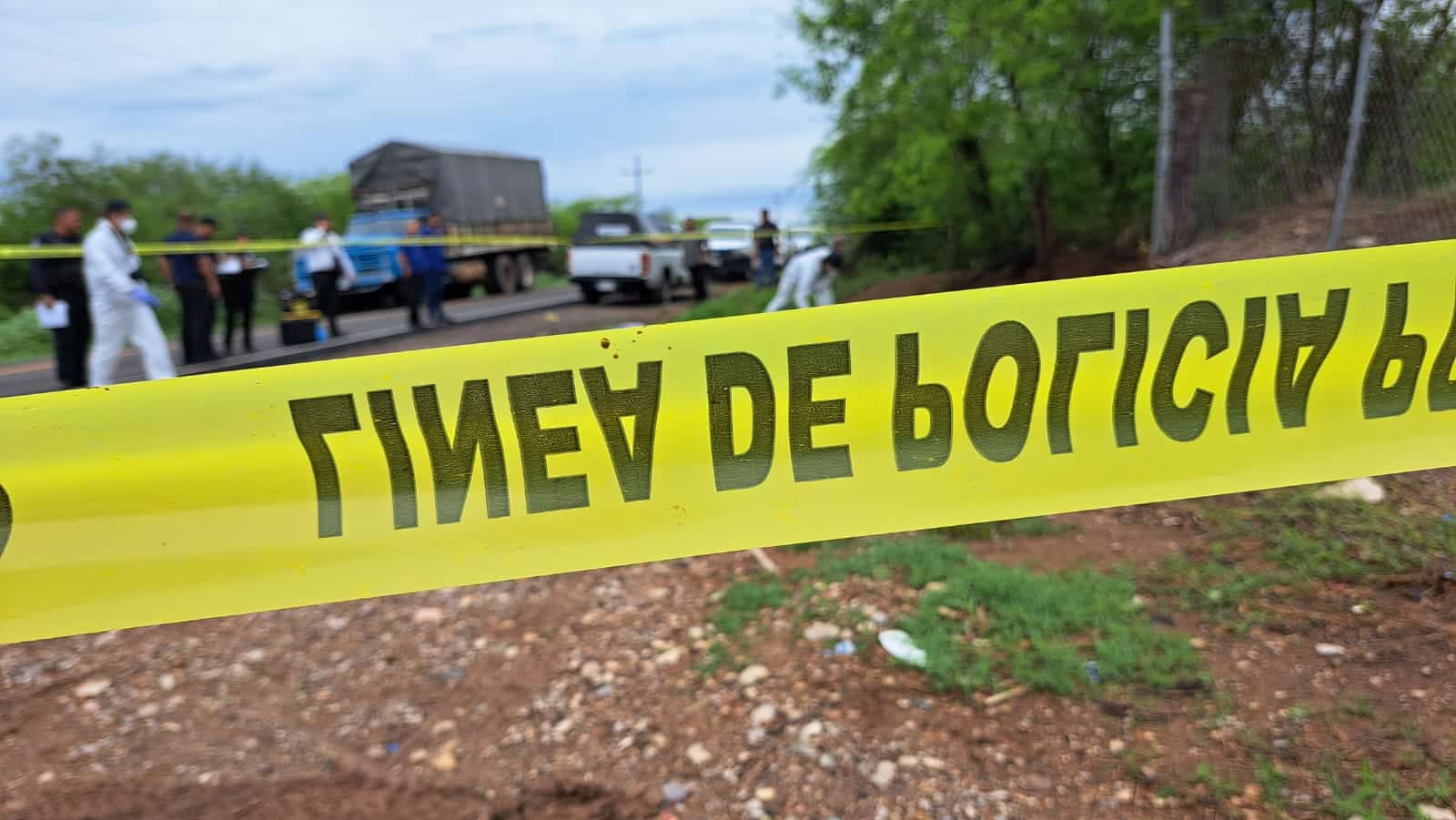 Cinta policial. Al fondo, peritos investigando el asesinato