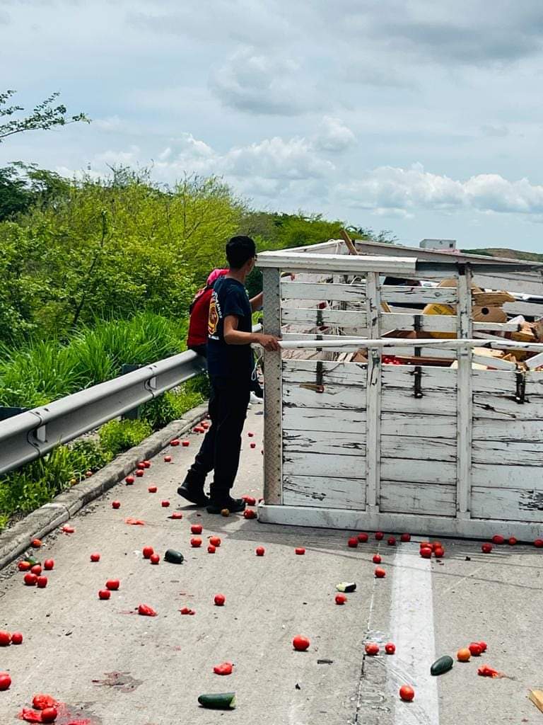 Vegetales que salieron de la caja de carga están regados por el pavimentos