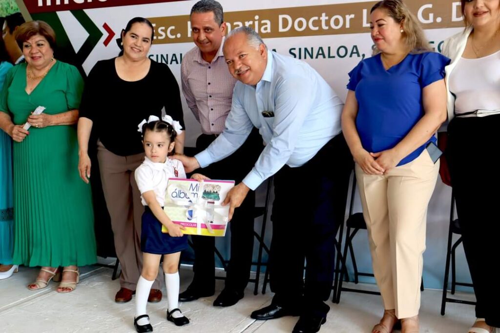 Alcalde Rolando Mercado entregando paquete de libros a estudiante de preescolar
