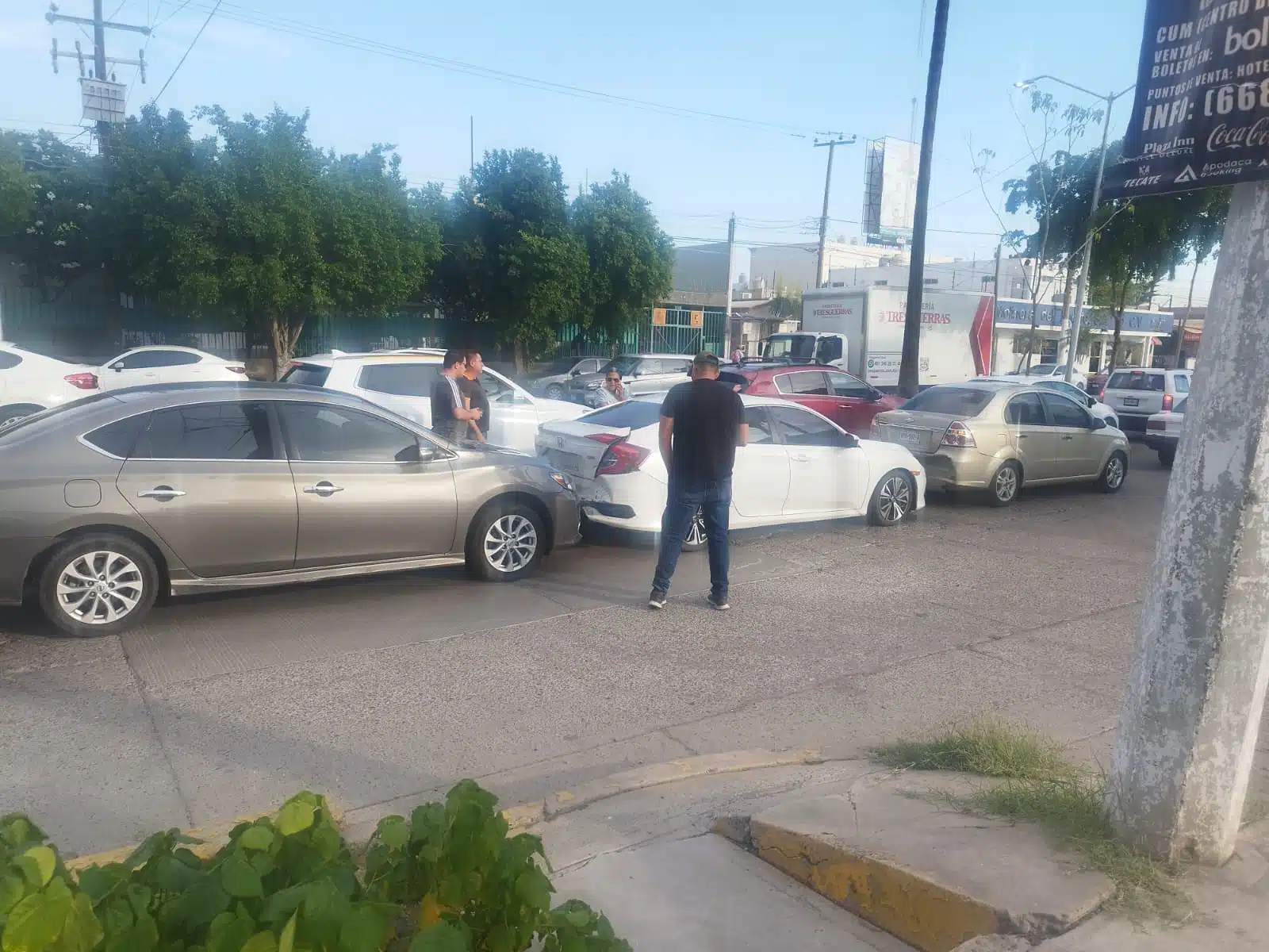 Choque múltiple entre tres vehículos en Los Mochis. Algunas personas observan de cerca lo ocurrido