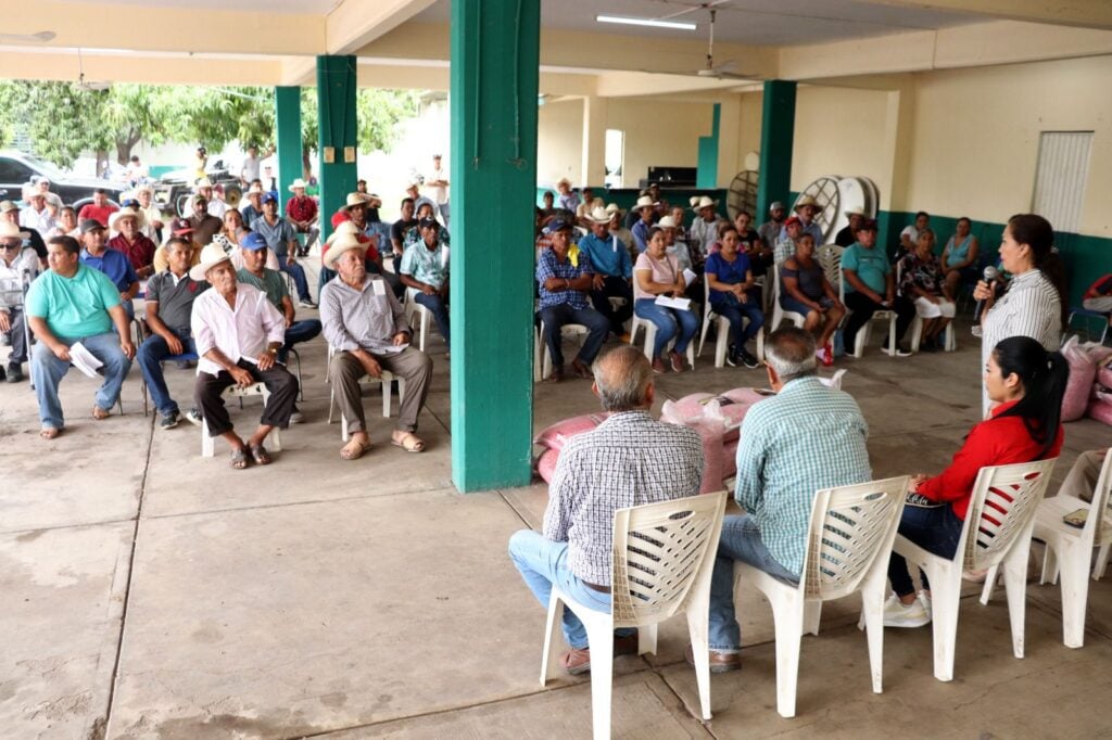 Más de 100 productores sentados en un espacio abierto durante la entrega de semillas