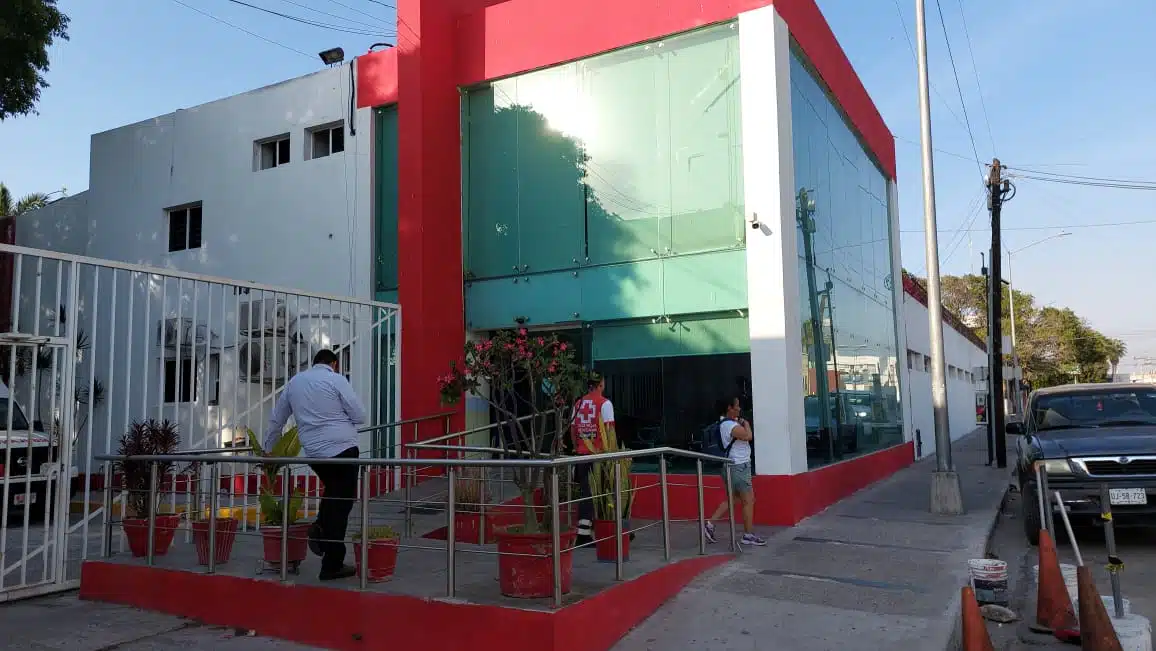 Exterior del hospital de la Cruz Roja. Personal y civiles se encuentran en la acera.