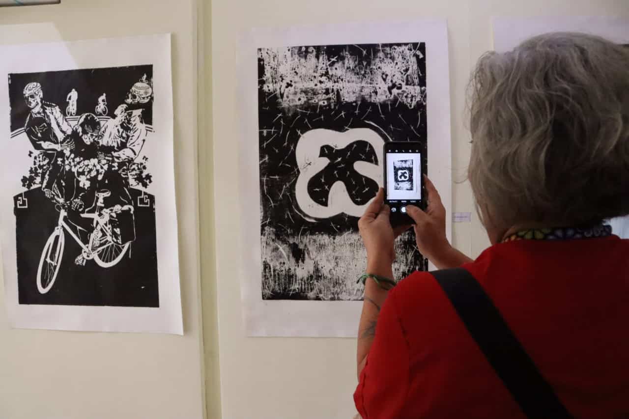 Persona tomando fotografía a pintura grabada en madera