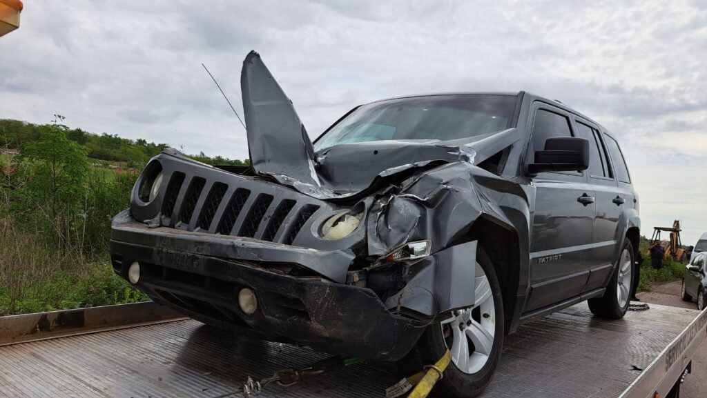 Camioneta chocada del frente arriba de una grúa