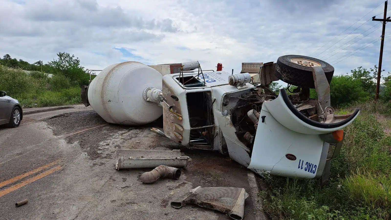 Camión revolver de cemento sobre su costado derecho en una carretera