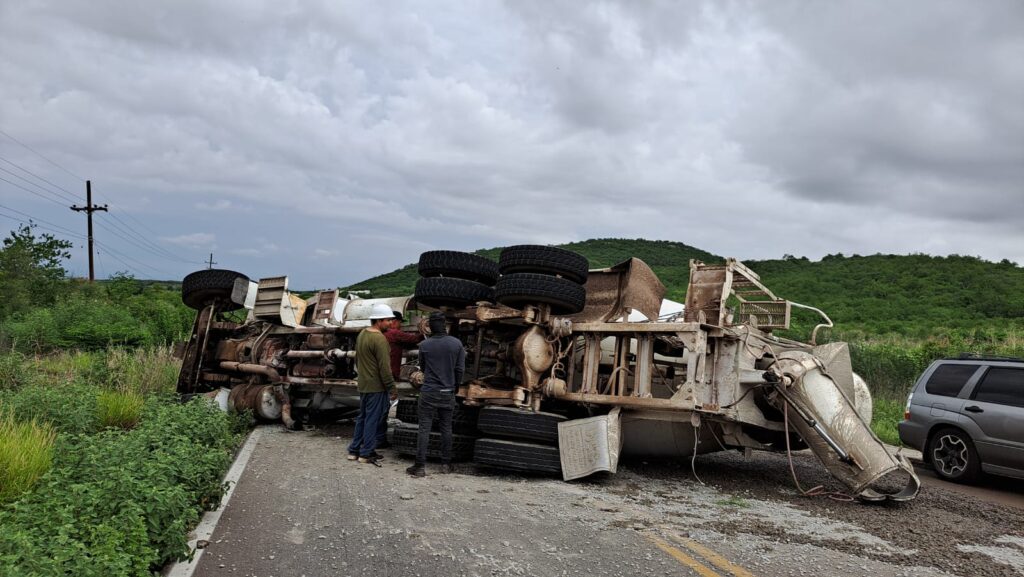 Camión revolver de cemento sobre su costado derecho en una carretera