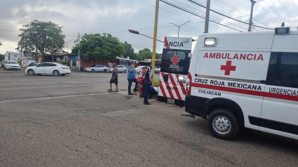 Una ambulancia de la Cruz Roja, personas, semáforos y carros