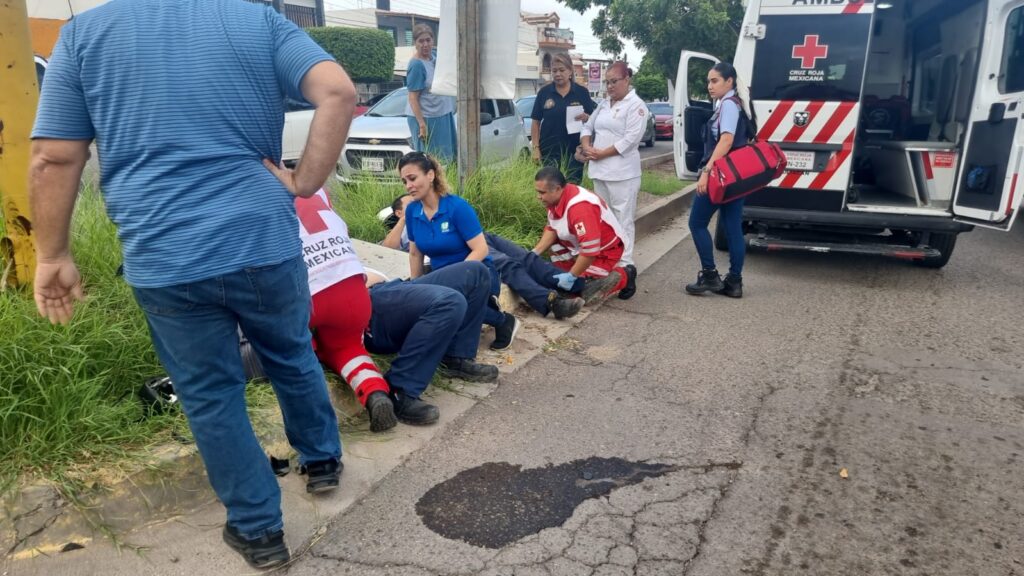 Ambulancia de la Cruz Roja con las puertas traseras abiertas y personal de la dependencia atendiendo a dos jóvenes
