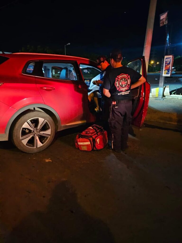 Una camioneta chocada y paramédicos ayudando a una persona