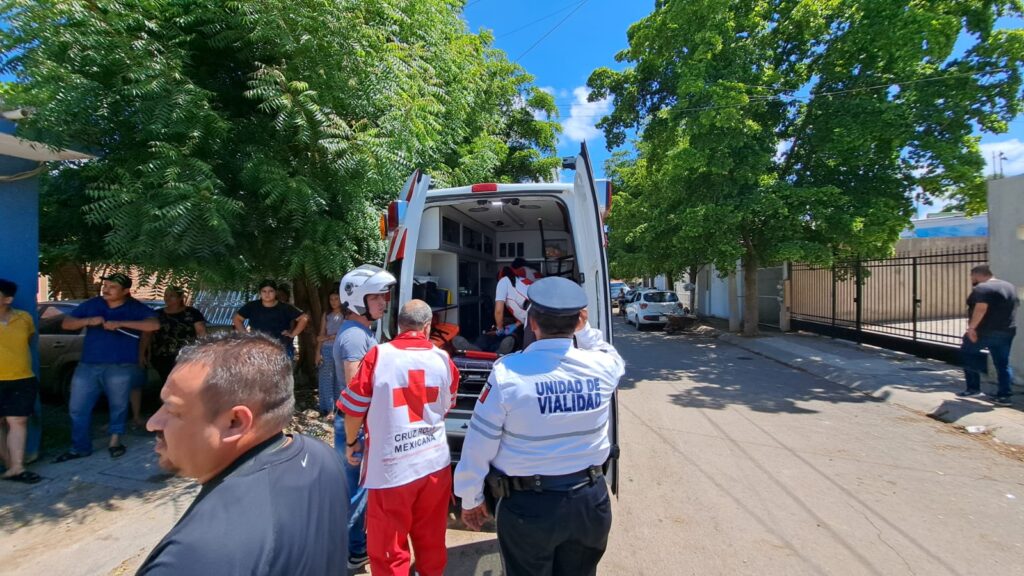 Una ambulancia de Cruz Roja con las puertas traseras abiertas, una camilla y personas