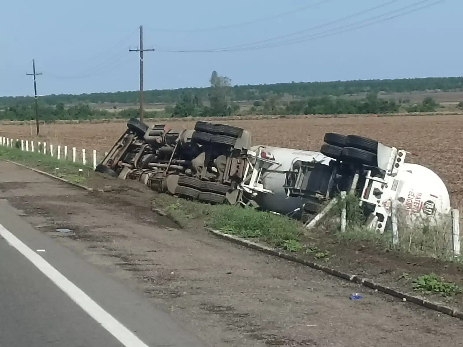 Tráiler tipo pipa volcado a un costado de la carretera