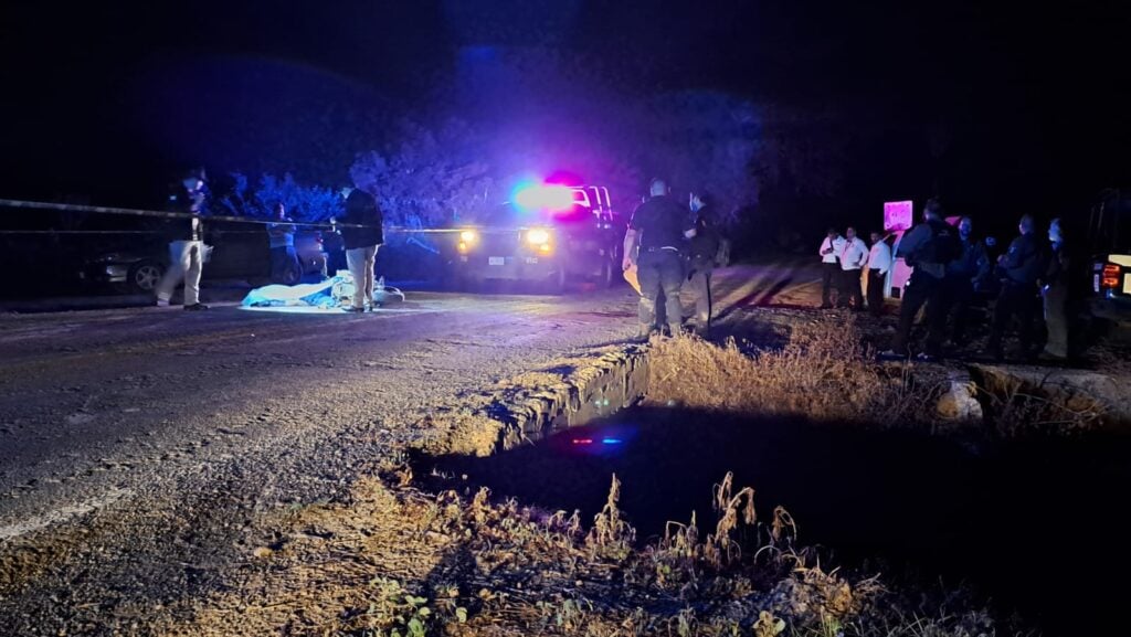 Motociclista tapado con una sábado en plena carretera tras ser asinado; policías en la escena