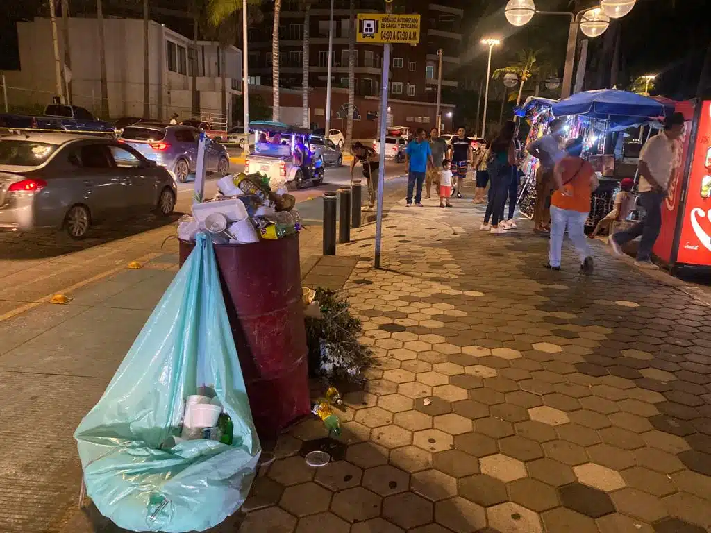 Calle con contenedores de basura llenos