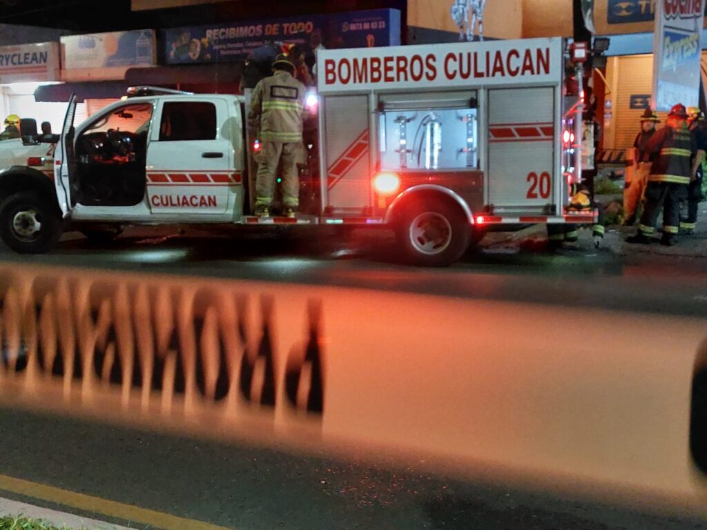 Bomberos trabajan en la escena de un accidente donde una camioneta se incendió en Culiacán