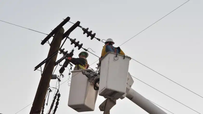 Trabajadores de CFE en poste de luz