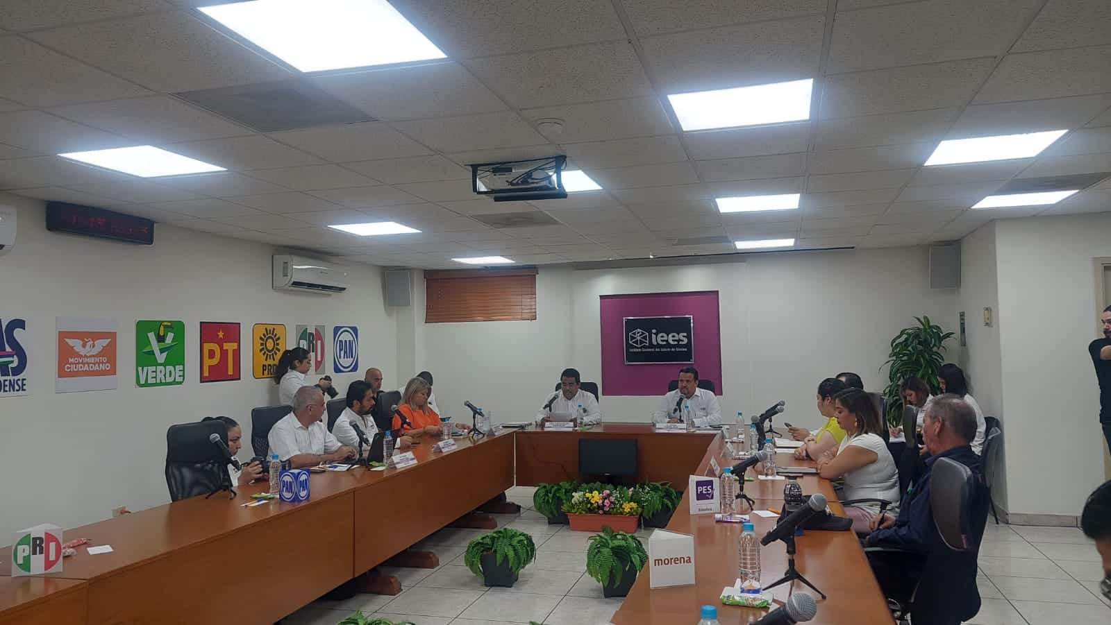 Personas sentadas en una mesa tipo cabildo